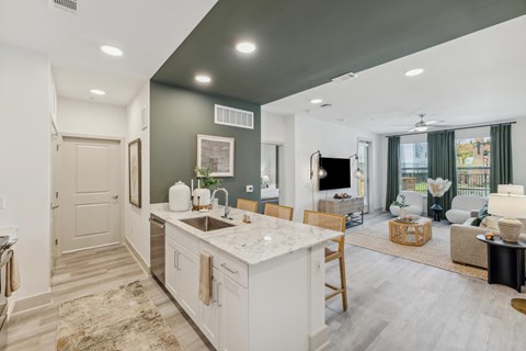 a kitchen with an island and a living room with a tv